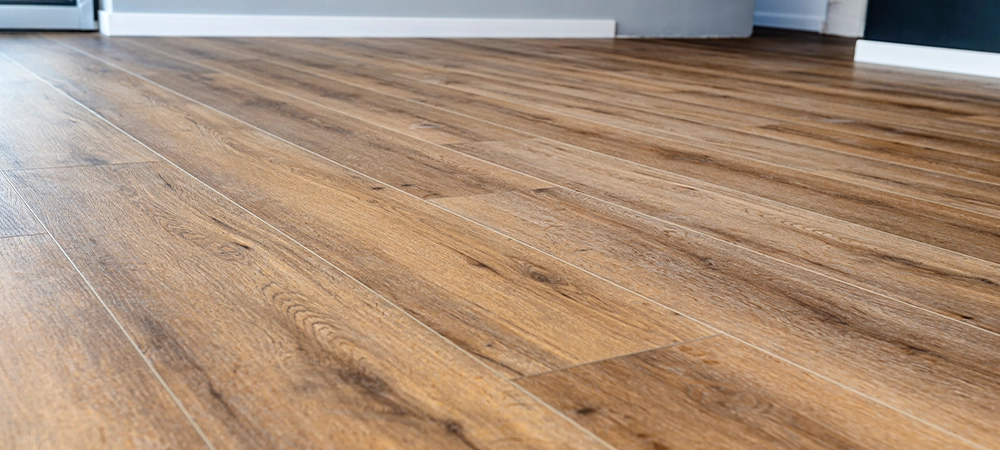 Modern vinyl panels imitating wood in the living room with selective focus and a shadow falling from the window.