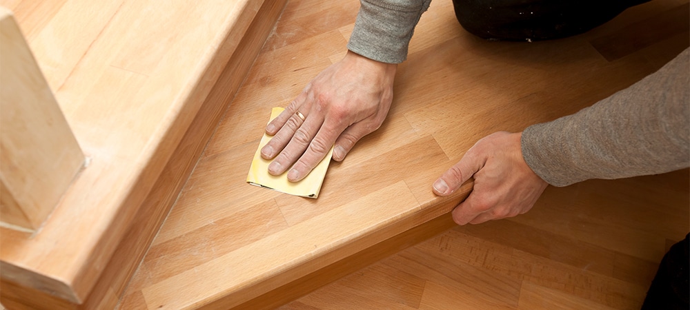 wood grinding process by sandpaper on stairs