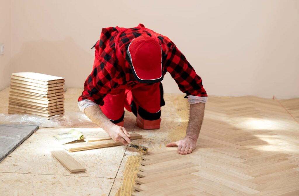 worker installing hardwood flooring