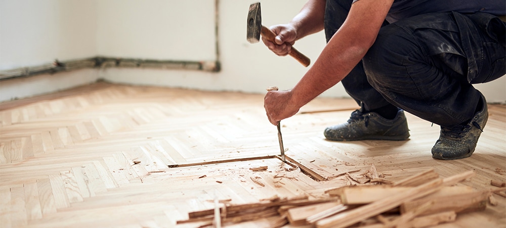 worker repairing wood floor